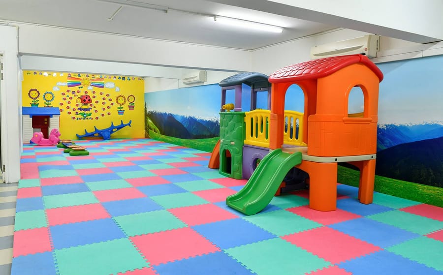 Play area with a slide and soft mats